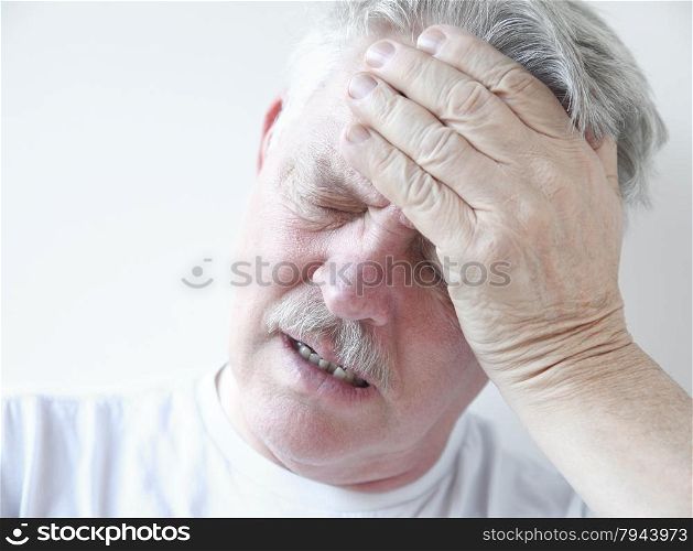 senior with hand on forehead frowning