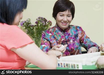 Senior woman and a mature woman playing mahjong