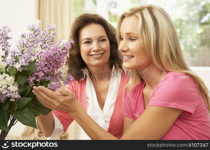 Senior Woman And Daughter At Home Arranging Flowers