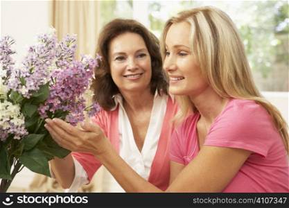 Senior Woman And Daughter At Home Arranging Flowers
