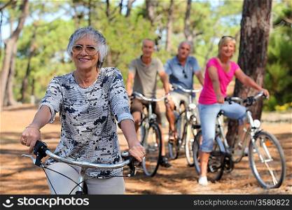 Senior woman and her friends riding bikes through the countryside