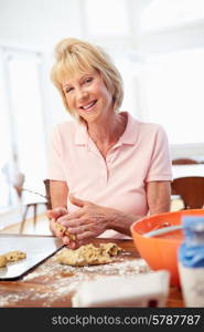 Senior Woman Baking Cookies In Kitchen