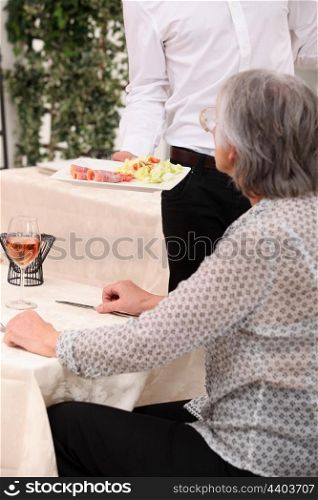 Senior woman being served