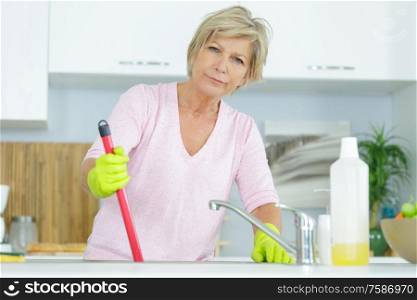 senior woman cleaning a kitchen sink