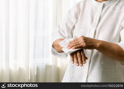 Senior woman cleaning her hands with white soft tissue paper. isolated on a white backgrounds