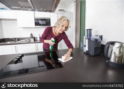 Senior woman cleaning kitchen counter