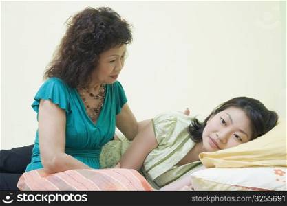 Senior woman consoling her daughter on the bed