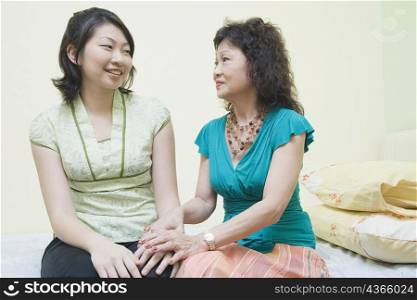 Senior woman consoling her daughter on the bed