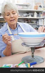 Senior Woman Decorating Bowl In Pottery Class