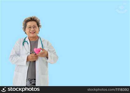 senior woman doctor with stethoscope smile holding heart on blue background.healthcare and medical concept.Senior woman doctor working in the hospital