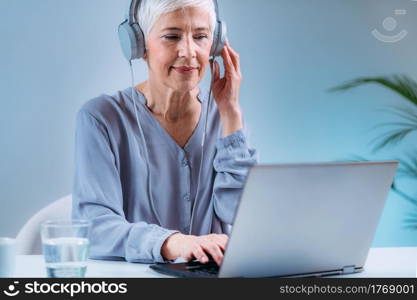 Senior Woman Doing Audiogram Hearing Test at Home, using Laptop