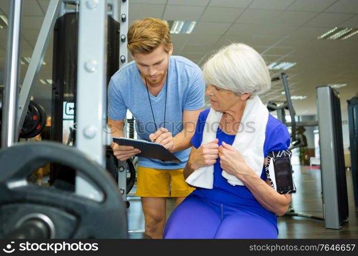 senior woman doing sport exercises with coach or personal trainer