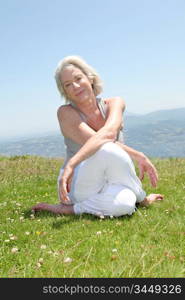 Senior woman doing stretching exercises in countryside