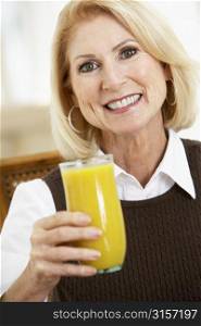 Senior Woman Drinking A Glass Of Fresh Orange Juice