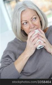 Senior woman drinking hot drink