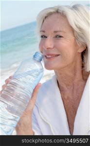 Senior woman drinking water from bottle