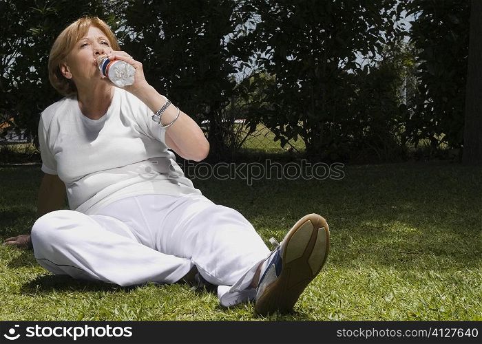 Senior woman drinking water in a garden