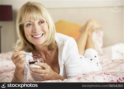 Senior Woman Eating Dessert In Bed