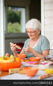 Senior woman eating on her terrace