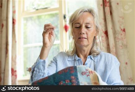 Senior Woman Embroidering Cushion Cover At Home
