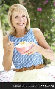 Senior Woman Enjoying Bowl Of Breakfast Cereal