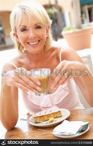 Senior Woman Enjoying Coffee And Cake In CafZ