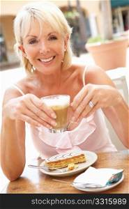 Senior Woman Enjoying Coffee And Cake In CafZ