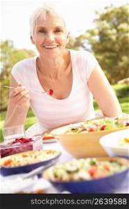Senior Woman Enjoying Meal In Garden