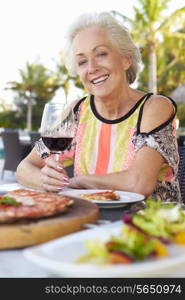 Senior Woman Enjoying Meal In Outdoor Restaurant