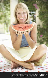 Senior Woman Enjoying Slice Of Water Melon