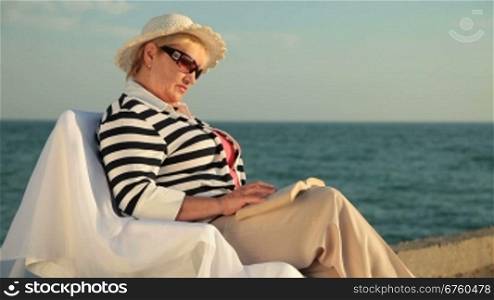 Senior woman enjoying vacation at the seaside during sunset