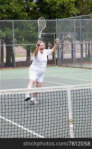 Senior woman excited about winning a tennis match.
