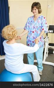 Senior woman exercises with the help of a physical therapist.