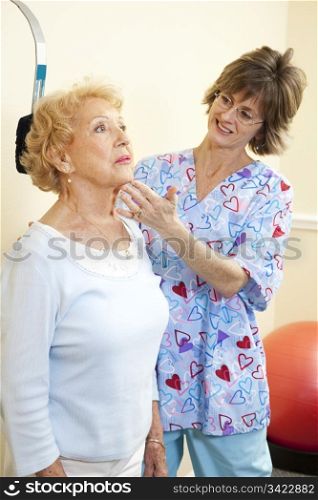 Senior woman exercising her neck with help from chiropractic physical therapist.