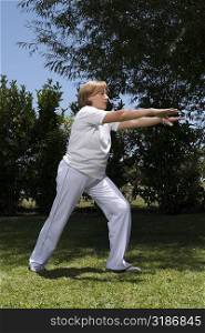 Senior woman exercising in a garden