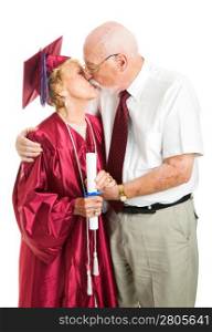 Senior woman gets a kiss from her husband on her graduation day. Isolated on white.