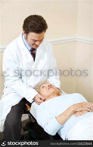 Senior woman gets her neck adjusted by a caring chiropractor.