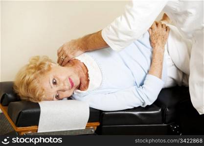 Senior woman getting an adjustment from her chiropractor.