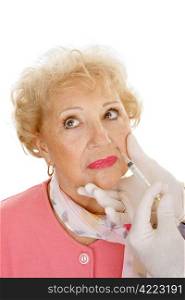 Senior woman getting cosmetic injections in the wrinkles around her mouth. White background.