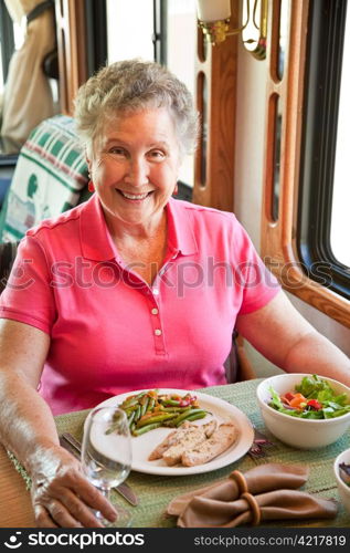 Senior woman having an elegant turkey dinner in her motor home.