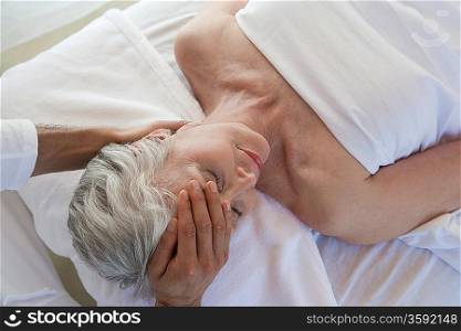 Senior woman having head massage