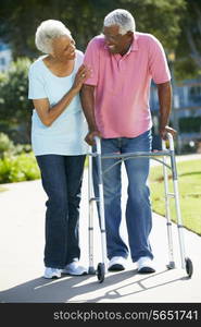 Senior Woman Helping Husband With Walking Frame