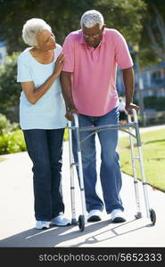 Senior Woman Helping Husband With Walking Frame