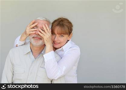 Senior woman hiding husband&acute;s eyes