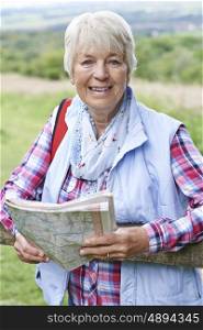 Senior Woman Hiking In Countryside With Map