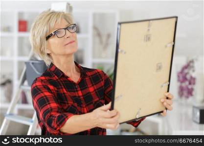 senior woman holding a frame