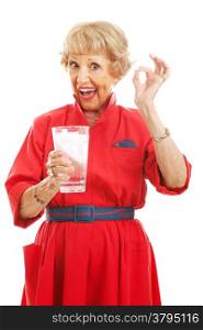 Senior woman holding a glass of ice water and giving the okay sign. Isolated on white