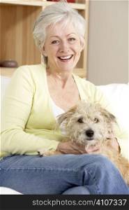 Senior Woman Holding Dog On Sofa
