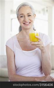 Senior Woman Holding Orange Juice And Smiling At The Camera