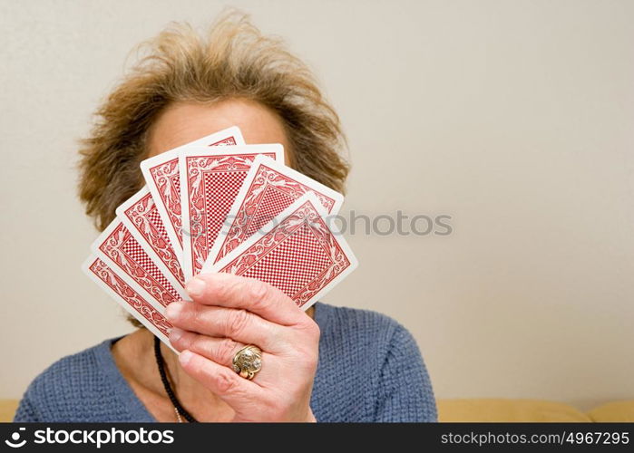 Senior woman holding playing cards